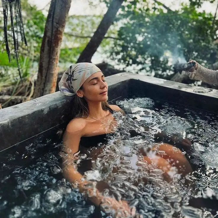 Woman relaxing in an outdoor ice bath during cold plunge therapy