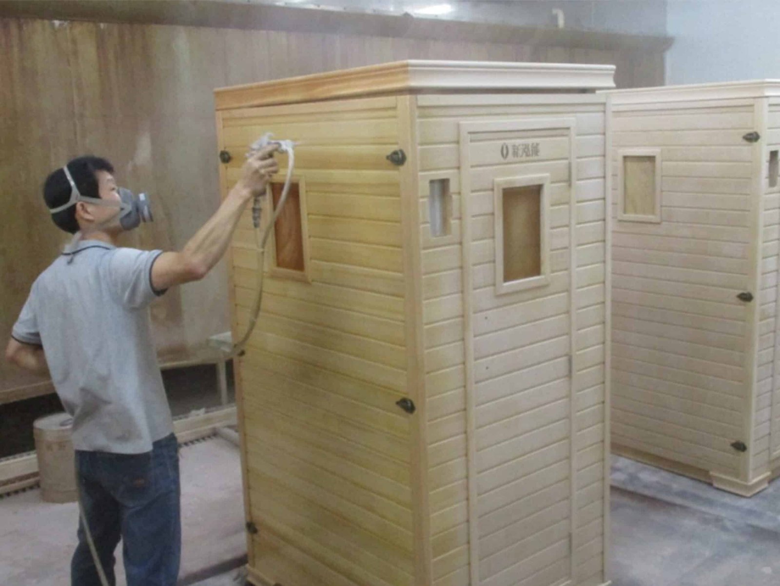 Technician assembling a wooden sauna cabin in the factory