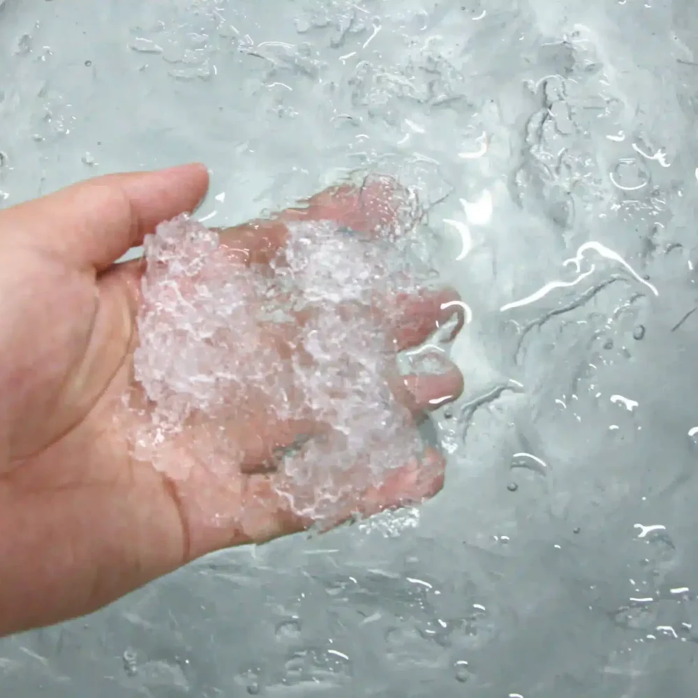 Cold plunge tub filled with icy water and visible ice cubes floating on the surface, demonstrating true ice-making capability